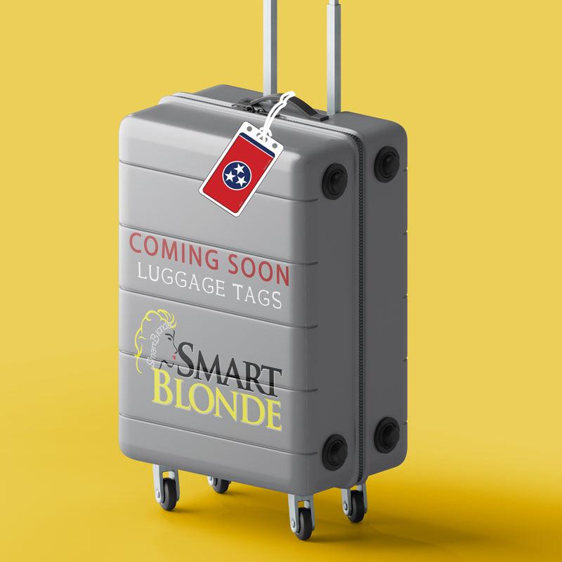 Gray suitcase with wheels, luggage tag, and 'Coming Soon Luggage Tags' text on yellow background