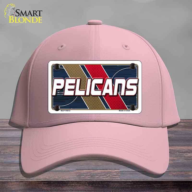 Pink cap with a 'Pelicans' logo on a wooden surface