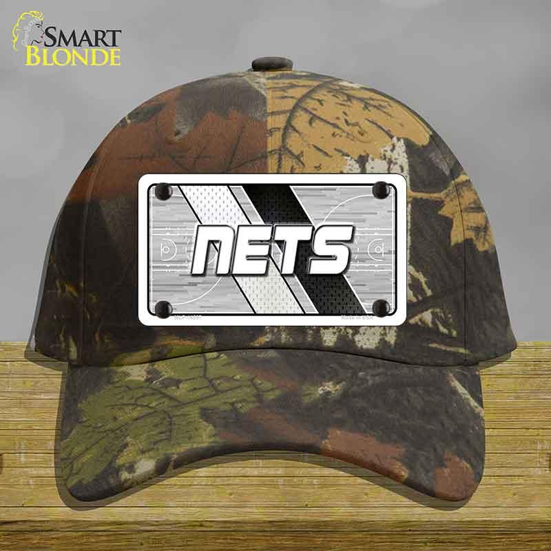 Camouflage cap with a 'NETS' logo on a wooden surface