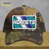 Camouflage cap with Hornets license plate design on a wooden surface