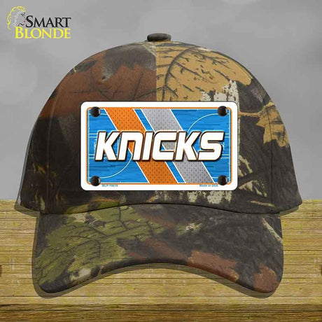 Camouflage cap with a 'Knicks' license plate design on a wooden surface.