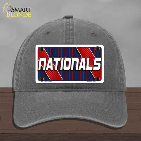Gray cap with 'NATIONALS' license plate design on a wooden surface