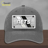 Gray cap with 'NETS' logo on a wooden surface and gray background