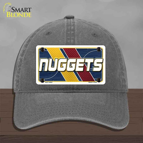 Gray cap with a 'NUGGETS' license plate design on a wooden surface