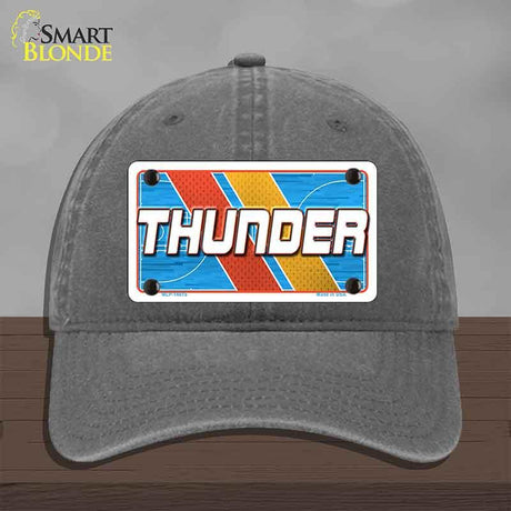 Gray cap with a 'THUNDER' license plate design on a wooden surface