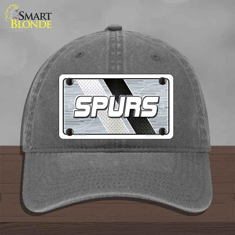 Gray cap with 'SPURS' logo on a wooden surface and gray background