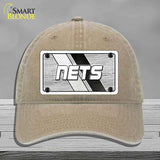Beige cap with a 'NETS' logo on a gray background