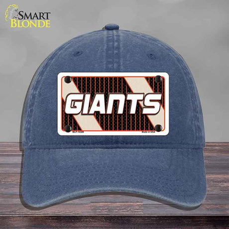 Blue cap with 'GIANTS' logo on a wooden surface and gray background