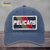Blue cap with 'Pelicans' logo on a wooden surface and gray background