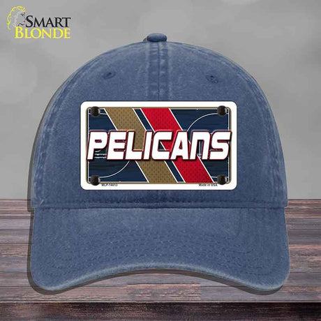 Blue cap with 'Pelicans' logo on a wooden surface and gray background