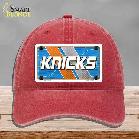 Red cap with a 'Knicks' logo on a gray background