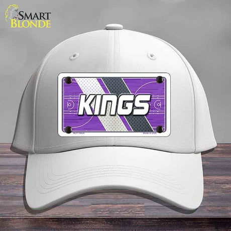 White cap with a purple and white 'KINGS' logo on a wooden surface