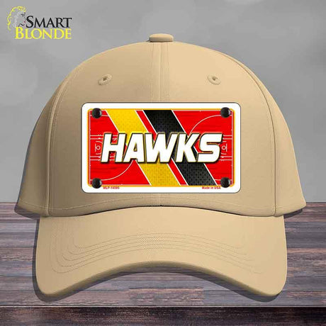 Beige cap with a 'HAWKS' license plate design on a wooden surface