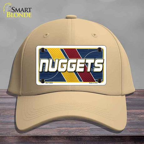Beige cap with a 'NUGGETS' license plate design on a wooden surface.