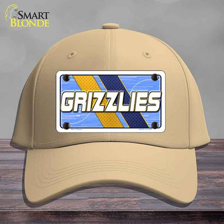 Beige cap with a 'GRIZZLIES' license plate design on a wooden surface.
