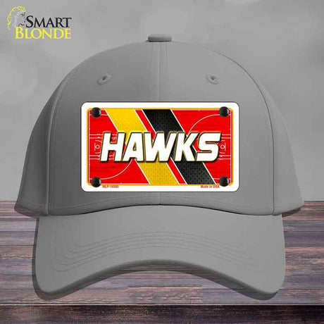 Gray cap with a red and yellow 'HAWKS' license plate design on a wooden surface.