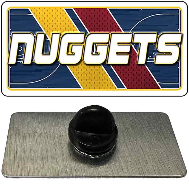Metallic badge with 'NUGGETS' logo on a reflective surface