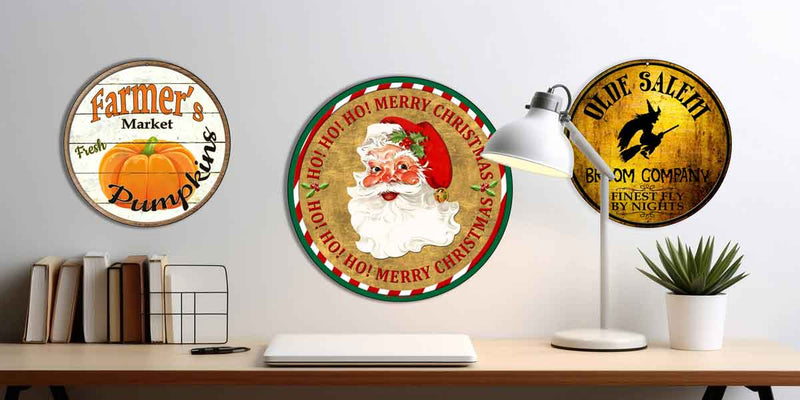 Three circular signs with festive designs on a desk.